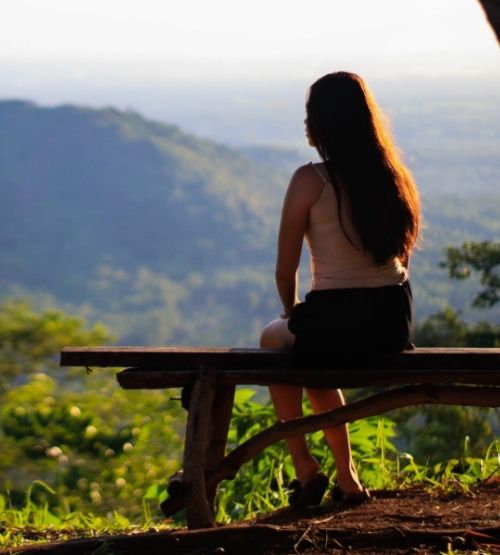 Femme assise face aux montagnes, au calme